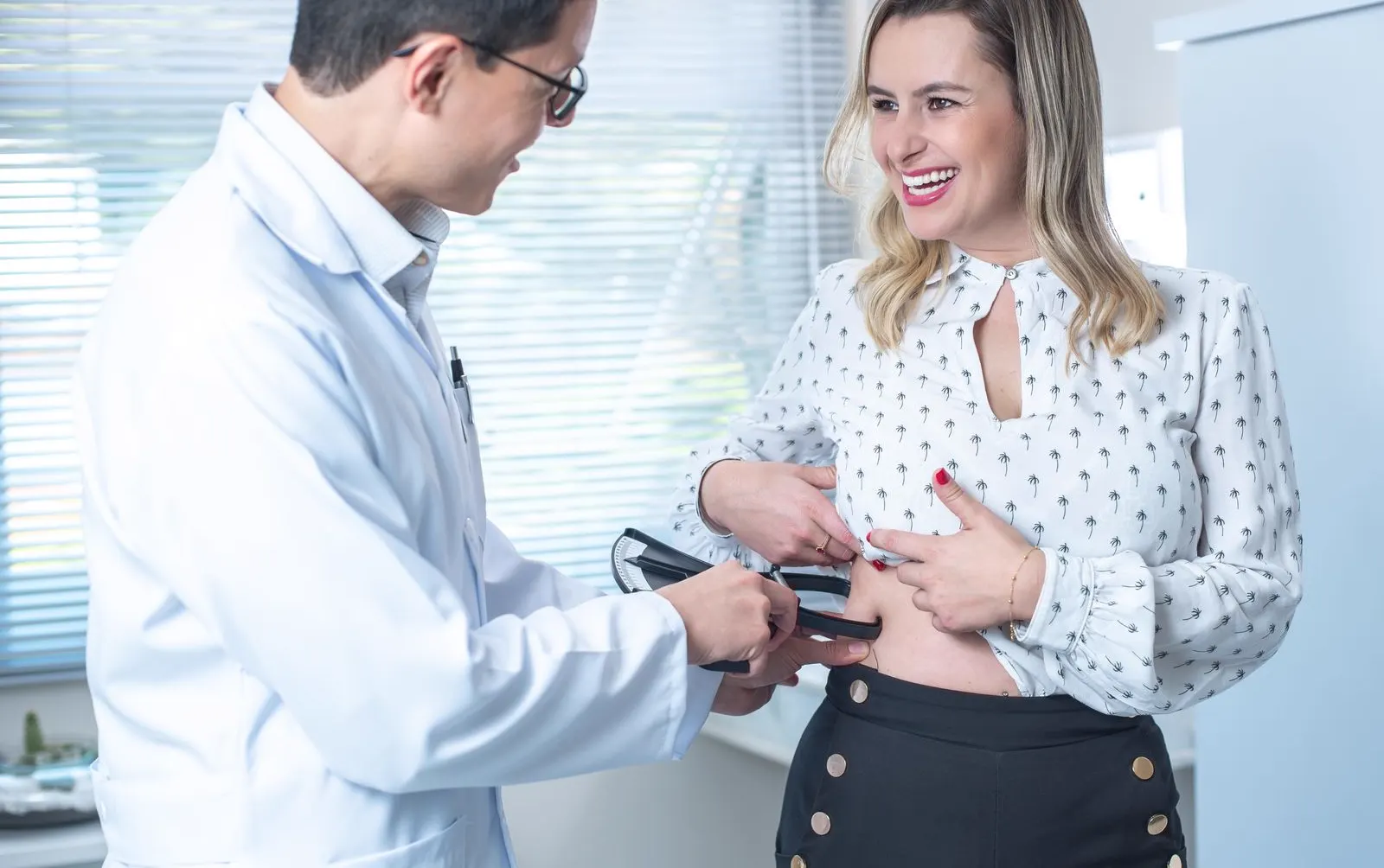 Médico realizando avaliação de composição corporal em consultório